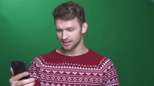 Feliz joven morena hombre de negocios hablando en videochat en el teléfono celular siendo alegre y atento sobre fondo verde . — Vídeos de Stock