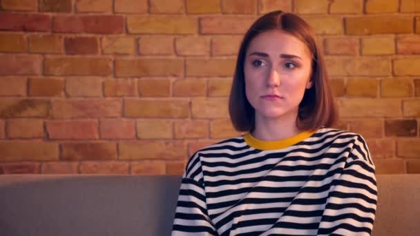 Gros plan portrait de jeune jolie fille regarder un film triste à la télévision presque pleurer assis sur le canapé dans un appartement confortable à l'intérieur — Video