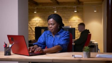 Dizüstü bilgisayar kullanarak yetişkin Afro-Amerikan iş kadını Closeup ateş ve ofis kapalı başarı kutluyor mutlu olmak