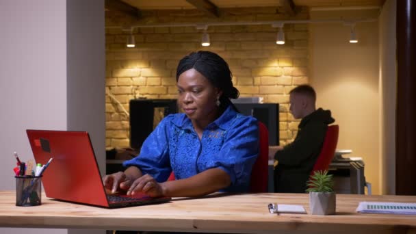 Closeup hajtás felnőtt afroamerikai üzletasszony segítségével a laptop, és hogy boldog ünneplő sikere az irodában beltéri — Stock videók