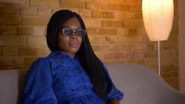 Tv'de bir 3d korku filmi izlerken yetişkin afro-amerikan kadın Closeup ateş ve kapalı kanepede oturan korkmuş olmak