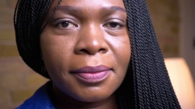 Yetişkin afro-amerikan kadın yüz closeup ateş mutlu rahat bir dairede kapalı kamera bakarak gülümseyerek