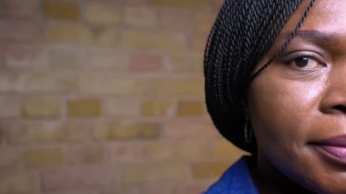 Yakın çekim yetişkin afro-amerikan kadın gülümseyerek mutlu rahat bir dairede kapalı kamera bakarak