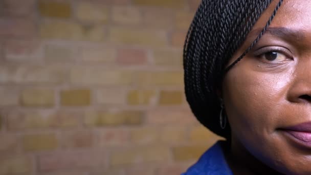 Крупный план съемки полулица взрослой африканской женщины-американки, счастливо улыбающейся, глядя на камеру в уютной квартире — стоковое видео