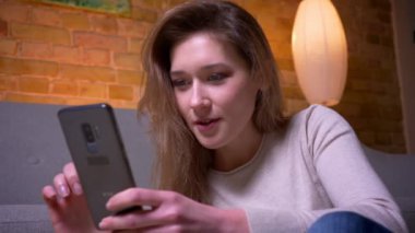 Genç çekici kafkas esmer kadın gezinen ağ closeup portre rahat bir dairede kapalı yerde oturarak