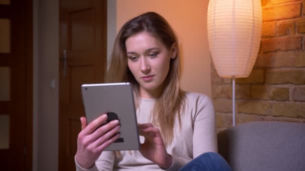 Zbliżenie Portret młodej atrakcyjnej kaukaski brunetka kobieta za pomocą tabletu i pokazując zielony ekran chrominancji z aplikacją do aparatu w pomieszczeniu w przytulnym płaskim — Wideo stockowe