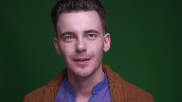 녹색에 고립 된 배경으로 카메라를 보고 흥분으로 미소 짓는 성인 매력적인 남자의 클로즈업 촬영 — 비디오