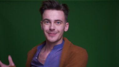 Kameraya dönen ve mutlu yeşil izole arka plan ile çığlık yetişkin çekici adam Closeup ateş