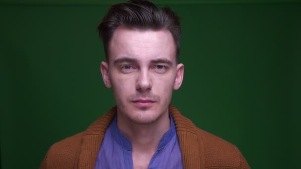Šneťák, přitažlivý muž s pokyvovaným pohledem na kameru, s pozadím izolovaným na zeleném — Stock video