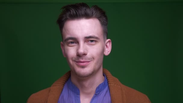 Closeup shoot of adult attractive man waving his head saying no looking at camera with background isolated on green — Stock Video