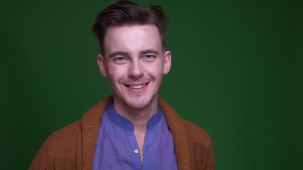 Closeup shoot of adult attractive man showing a thumb up and smiling looking at camera with background isolated on green — Stock Video