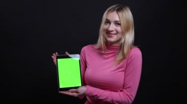 Tablet kullanarak genç güzel sarışın kadın Closeup ateş ve siyah izole arka plan ile kameraya yeşil ekran gösteren