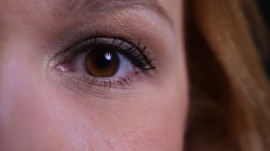 Yetişkin çekici beyaz kadın gözünün closeup yarım yüz portresi kameraya bakarak