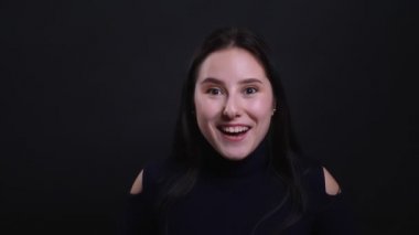 Siyah izole arka plan ile kamera bakarak heyecanlı ve şaşırmış genç çekici esmer kadın Closeup portre