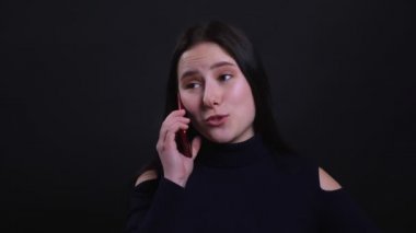 Siyah izole arka plan ile neşeyle gülümseyen bir telefon görüşmesi olan genç çekici esmer kadın Closeup portre