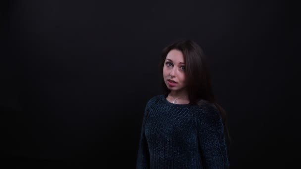 Closeup portrét dospělé krásné kavkazské brunety, která si připevní vlasy a svůdně se dívá na kameru s pozadím na černém — Stock video