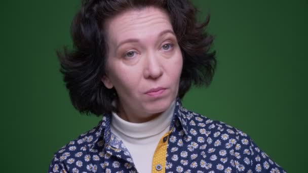 Closeup portrét staré kavkazské bruneté ženy pokyvující Ano pohledem na fotoaparát s pozadím izolovaným na zeleném — Stock video