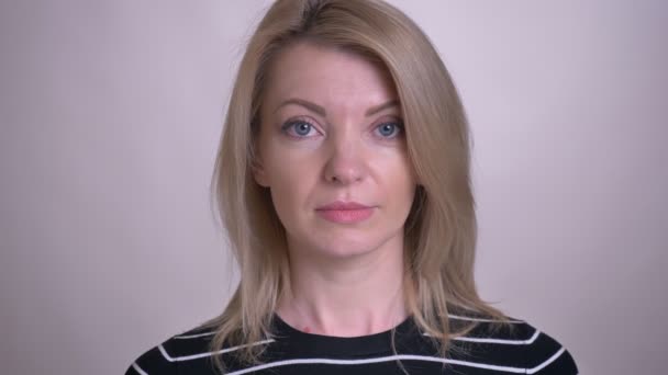 Retrato de close-up de adulto atraente rosto feminino caucasiano olhando para a câmera com fundo isolado no branco — Vídeo de Stock