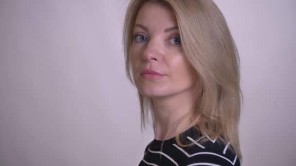 Close-up retrato de adulto atraente loira caucasiano feminino transformando e olhando para a câmera com fundo isolado no branco — Vídeo de Stock