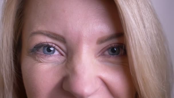Closeup portréja felnőtt vonzó kaukázusi női arc szemmel nézett kamera boldog arckifejezés háttérrel izolált fehér