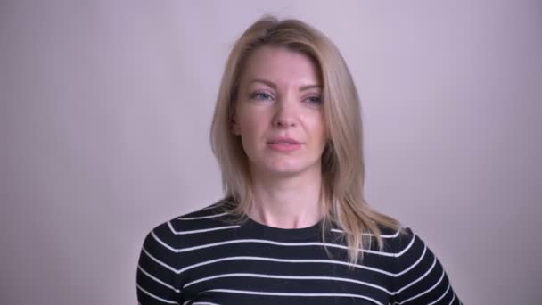 Closeup portrét dospělé atraktivní blond kavkazské ženy, která se zlobí a dělá oči pohledem na fotoaparát s pozadím izolovaným na bílém — Stock video