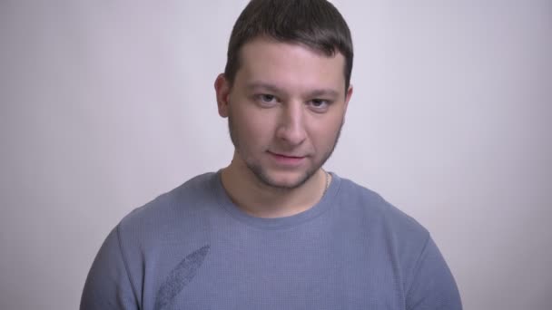 Closeup retrato de adulto atraente caucasiano homem levantando a cabeça e sorrindo alegremente olhando para a câmera com fundo isolado no branco — Vídeo de Stock