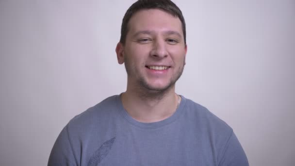 Closeup portrét dospělého muže, který se radostně směje a dívá se na kameru s pozadím izolovaným na bílém — Stock video