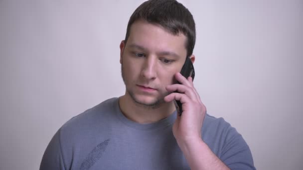 Close-up retrato de adulto atraente caucasiano homem ter um telefonema com fundo isolado no branco — Vídeo de Stock