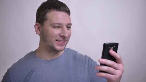 Zbliżenie portret dorosłych atrakcyjny kaukaski mężczyzna biorąc selfie na telefon z tłem na białym tle — Wideo stockowe