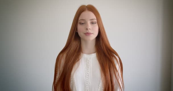 Portret pięknego modelu imbiru obserwując spokojnie w aparacie na białym tle. — Wideo stockowe