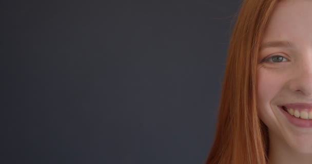Close-up half gezicht portret van mooie gember model glimlachend gelukkig in de camera op zwarte achtergrond. — Stockvideo