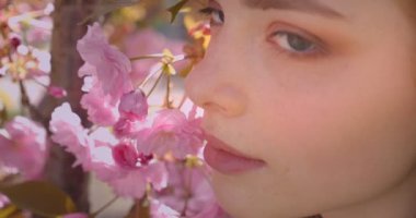 Pembe çiçek park arka planda kamera içine barışçıl ve güzel izlerken güzel zencefil modeli nin yakın çekim portre.