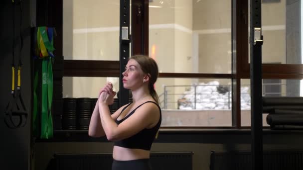 Jonge gemotiveerde sportmeisje doet lunges wordt geconcentreerd en serieus in de sportschool. — Stockvideo