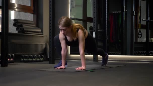 Ung och trött motiverad idrottsflicka gör lungor koncentreras i gym. — Stockvideo