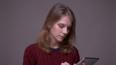 Genç kız öğrenci uygulamayı tablet üzerinde açar ve gri arka planda yeşil renk ekranı gösterir.