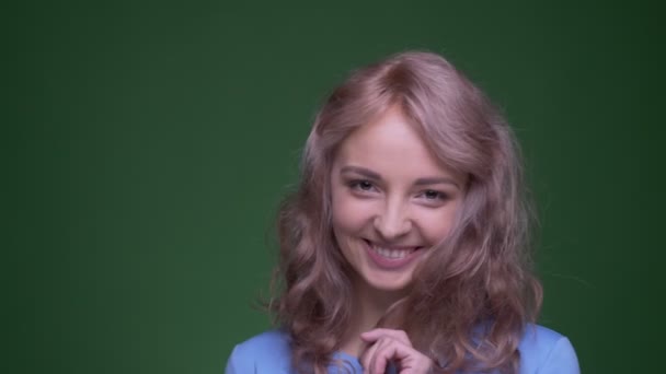 Mooi model met golvend lang haar speelt met haar haar flirten met camera op groene Chroma achtergrond. — Stockvideo