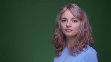 Dalgalı uzun saçlı pretty modeli moda yeşil renk arka plan üzerinde pozisyonları değişen poz.