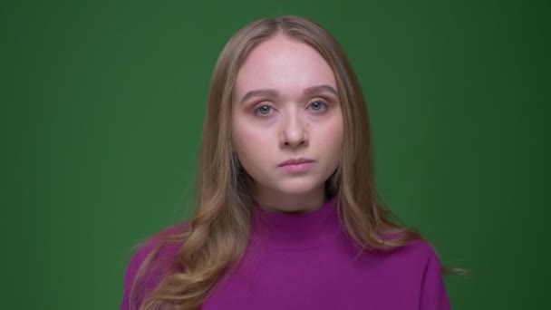 Portrait of beautiful ginger student watching calmly into camera on green chroma background. — Stock Video