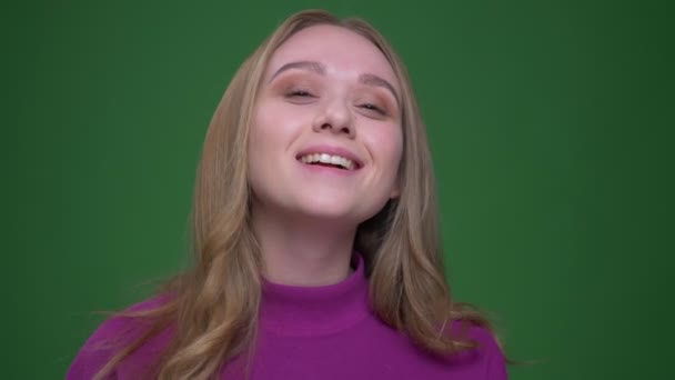 Portrait of beautiful ginger student smiling prettily into camera on green chroma background. — Stock Video