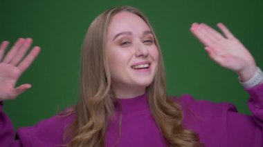 Yeşil renk arka planda kameraya sevinçle konuşan güzel zencefil kadın vlogger Portresi.