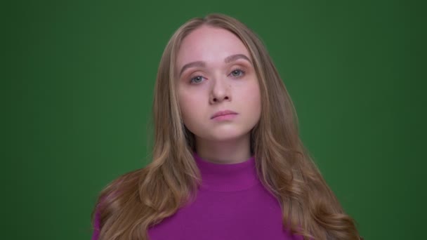 Retrato de una hermosa estudiante escuchando atentamente asiente de acuerdo con el fondo de croma verde . — Vídeos de Stock