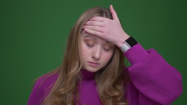 Deprimida estudiante de jengibre con horrible migraña tocando su frente sobre fondo de croma verde . — Vídeos de Stock