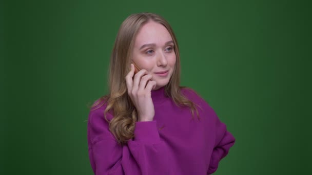 Hübsche Ingwerunternehmerin, die auf dem Smartphone spricht, aufmerksam und fröhlich auf grünem Chroma-Hintergrund. — Stockvideo