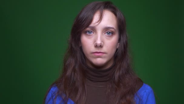 Porträtt av deprimerad brunett affärskvinna tittar sorgligt i kameran på grön bakgrund. — Stockvideo