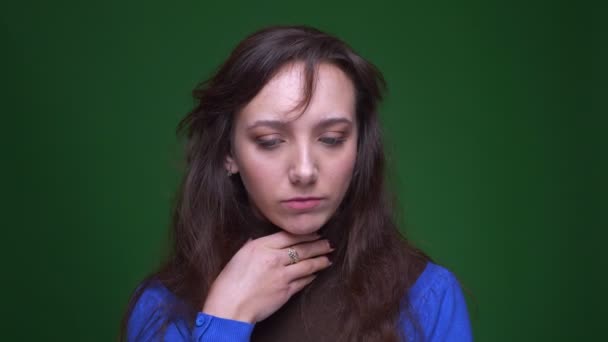 Portrait of depressed brunette businesswoman suffering from sore throat and cough on green background. — Stock Video