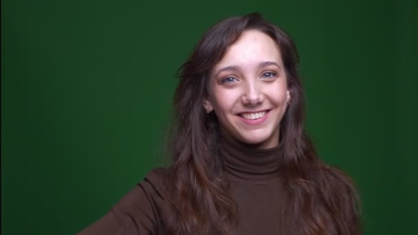 Young brunette female student dubbing being happy and satisfied on green background. — ストック動画