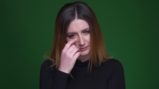 Ung affärskvinna med kastanj hår tittar eländigt in i kameran att vara redo att gråta på grön bakgrund. — Stockvideo