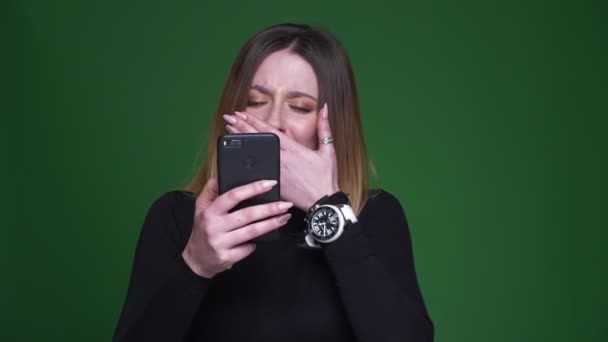 Empresária trabalhando com celular fica muito engraçado e explode em rir no fundo verde . — Vídeo de Stock
