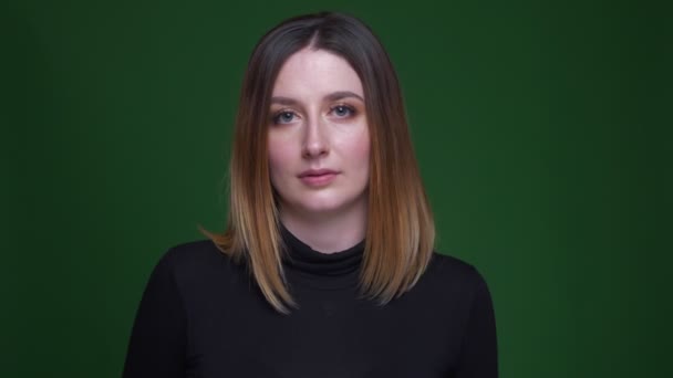 Retrato de una joven mujer de negocios con gestos de cabello castaño signo ok estar satisfecho y feliz sobre fondo verde . — Vídeos de Stock