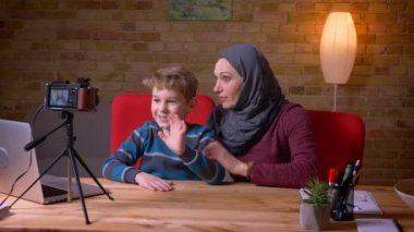 Küçük çocuk ve başörtüsü içinde müslüman annesi kamera vloggers olarak video kayıt.